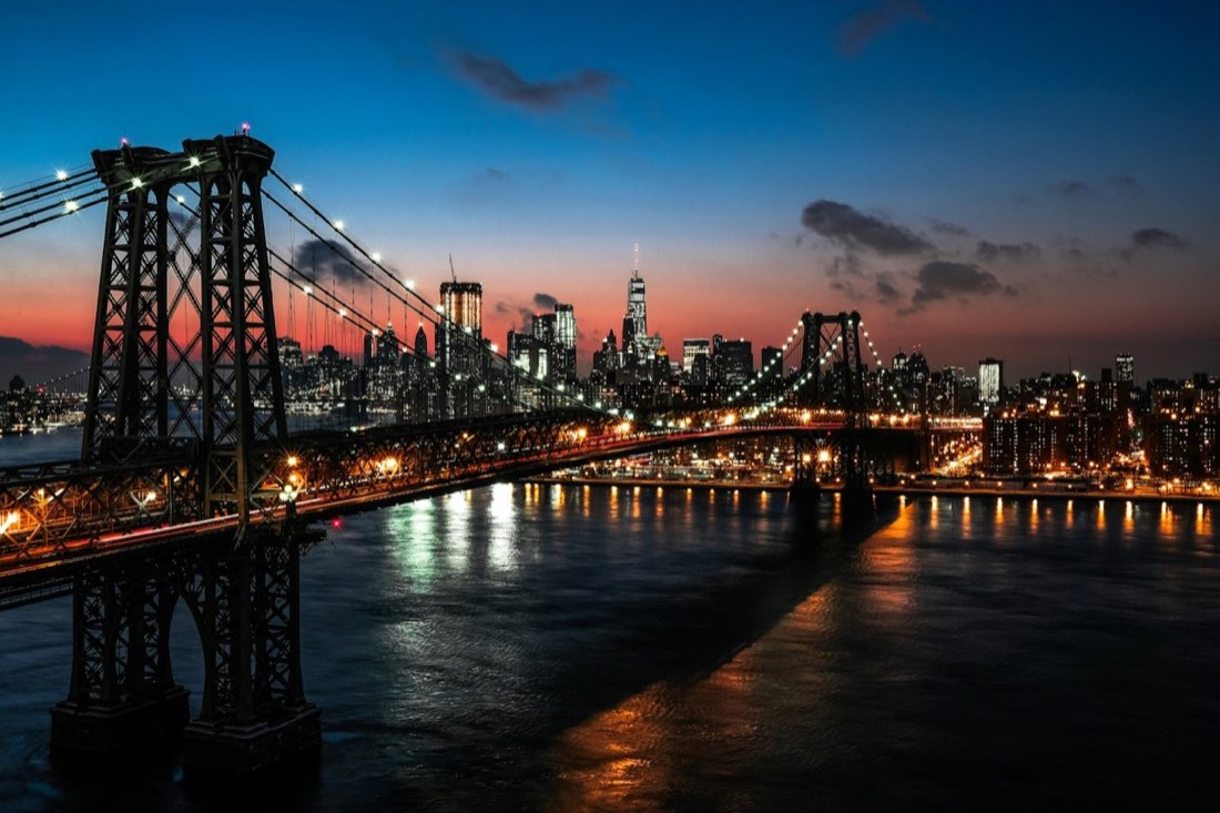 Manhattan bridge and skyline lit up at night