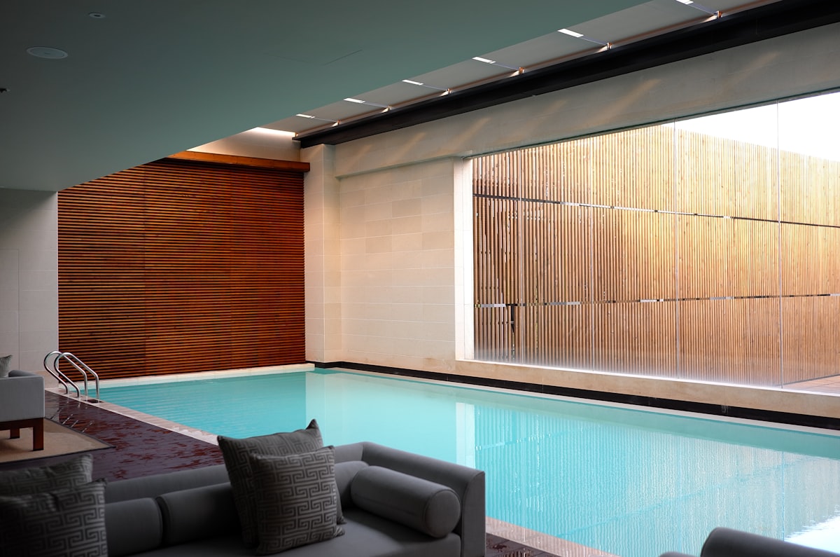 Indoor swimming pool with loungers and wooden accents