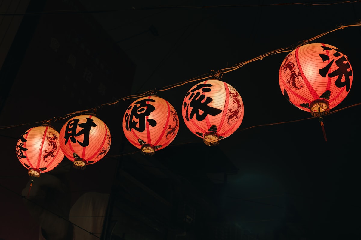 Red lanterns lit up over a night market street