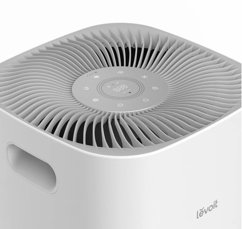 Close-up of the top intake grille and circular touch control panel of a Levoit air purifier