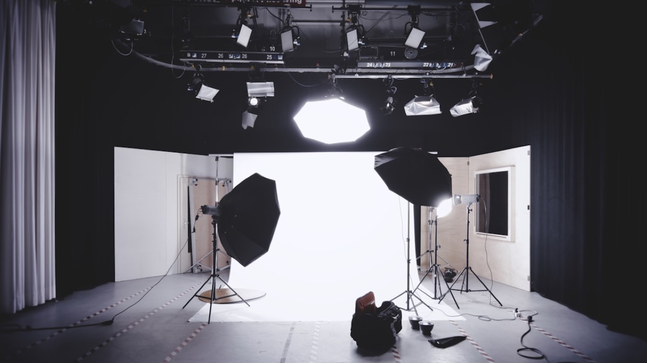 Photography studio interior with lighting rigs, umbrella lights and a white backdrop