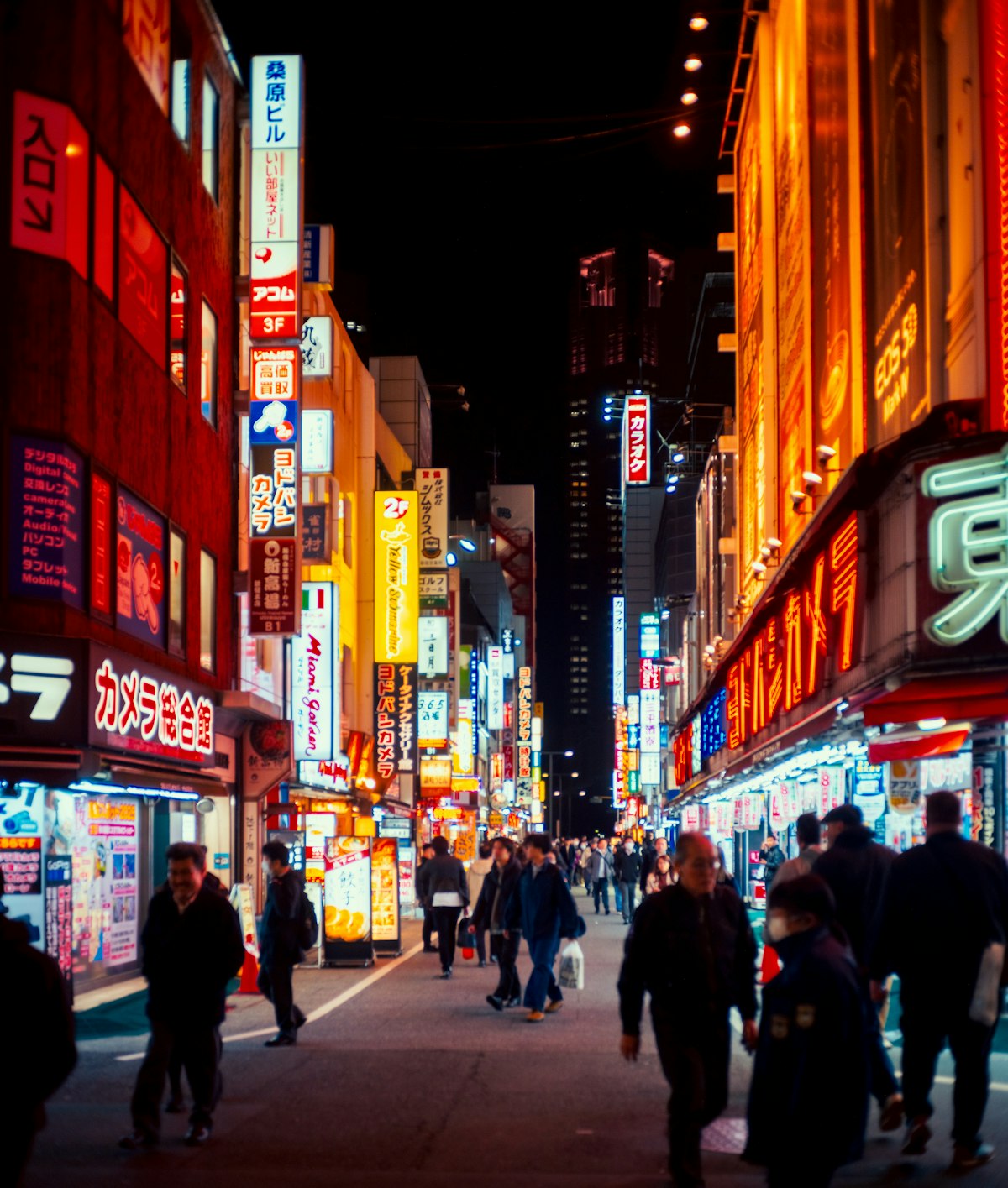 A busy Tokyo street at night with neon signs