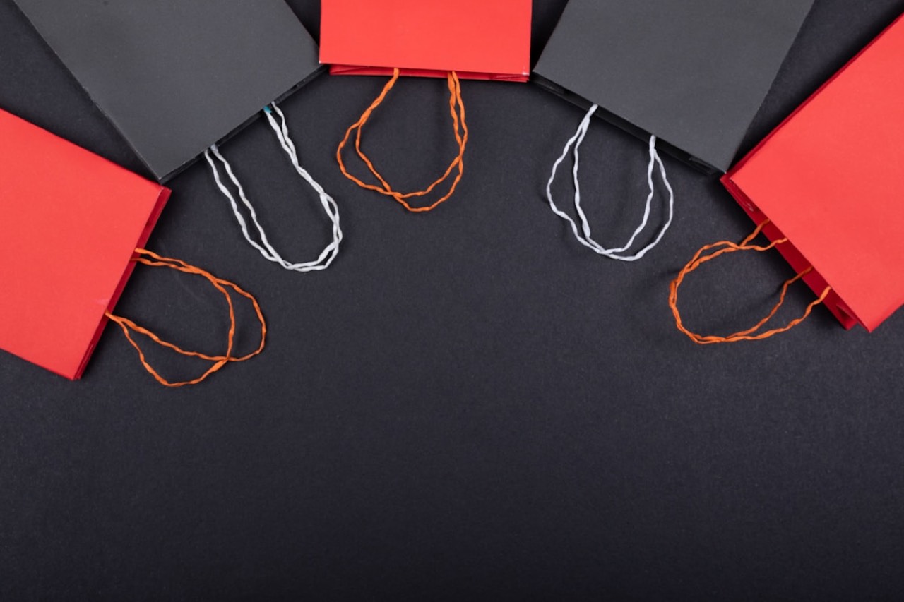 Red and black Shopee shopping bags arranged on a dark background