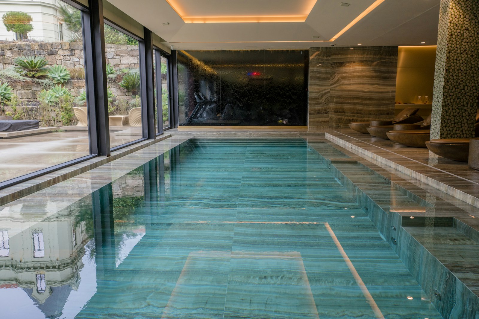 Long indoor swimming pool with reflective tiled walls